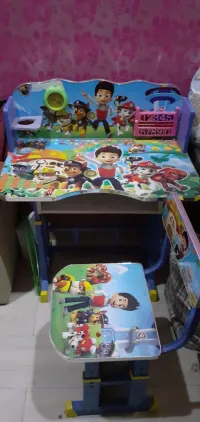 Un lots de jouets et une table avec chaise