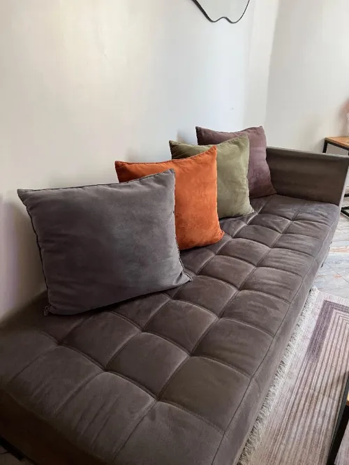 Fauteuil gris en L avec coussins
