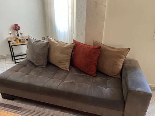 Fauteuil gris en L avec coussins