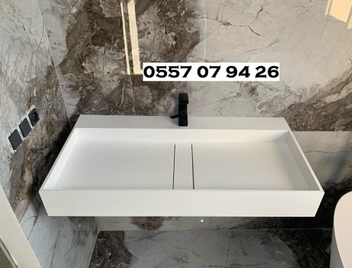 Lavabo incliné siphon central caché en CORIAN